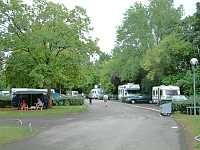 Vorschaubild: Camping du Lac Kir in Dijon Viele schattenspendende Bäume. Die Wiesenflächen in der Mitte, werden umrundet von der Hauptfahrstraße und geteilt von breiten Verbindungswegen.