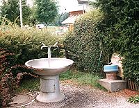 Vorschaubild: Camping Lazy Rancho in Interlaken Wie Brunnen sind die Wasserstellen gestaltet. Rechts, mit dem blauen Deckel, der Abwasser- und Chemietoilettenabfluss